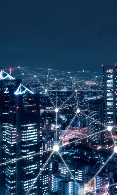 Nächtliche Stadtansicht mit leuchtenden Hochhäusern und einem darüberliegenden Datennetzwerk